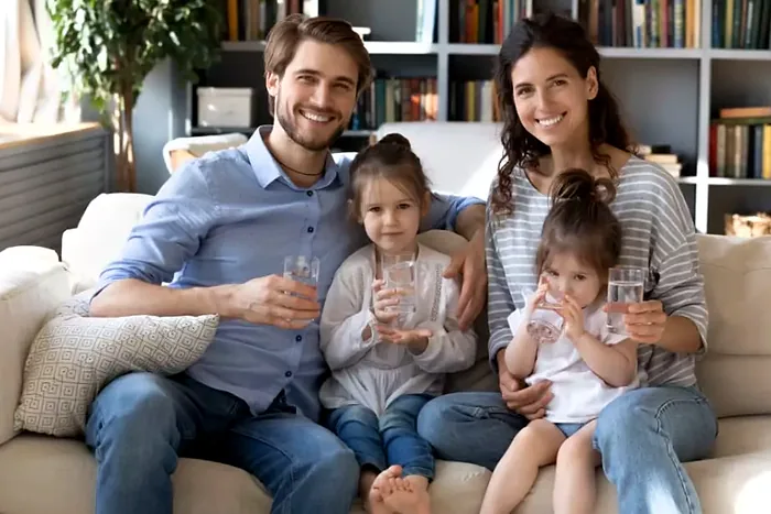 Familia en casa con vasos de agua