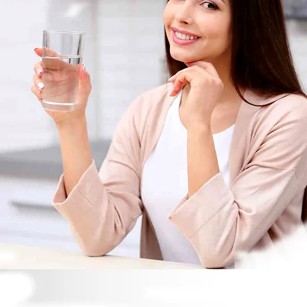Mujer sonriente con un vaso de agua purificada